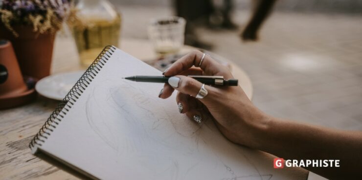 graphiste dessine avec un papier et un crayon